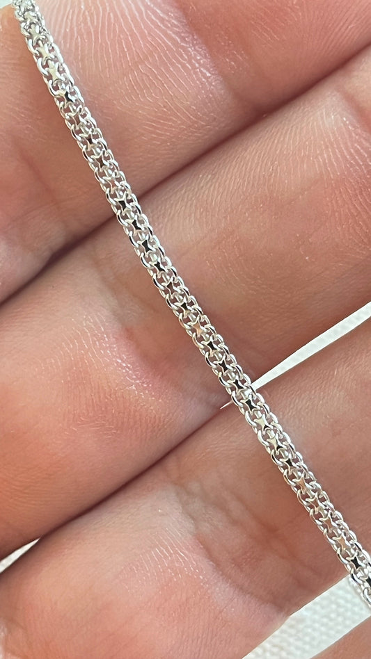 Bracelet chaîne Tank en argent 925 posé sur les doigts, vue rapprochée de la maille plate