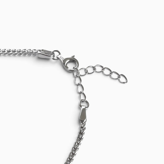 Bracelet chaîne en argent rhodié maille franco posé à plat, avec son fermoir mousqueton
