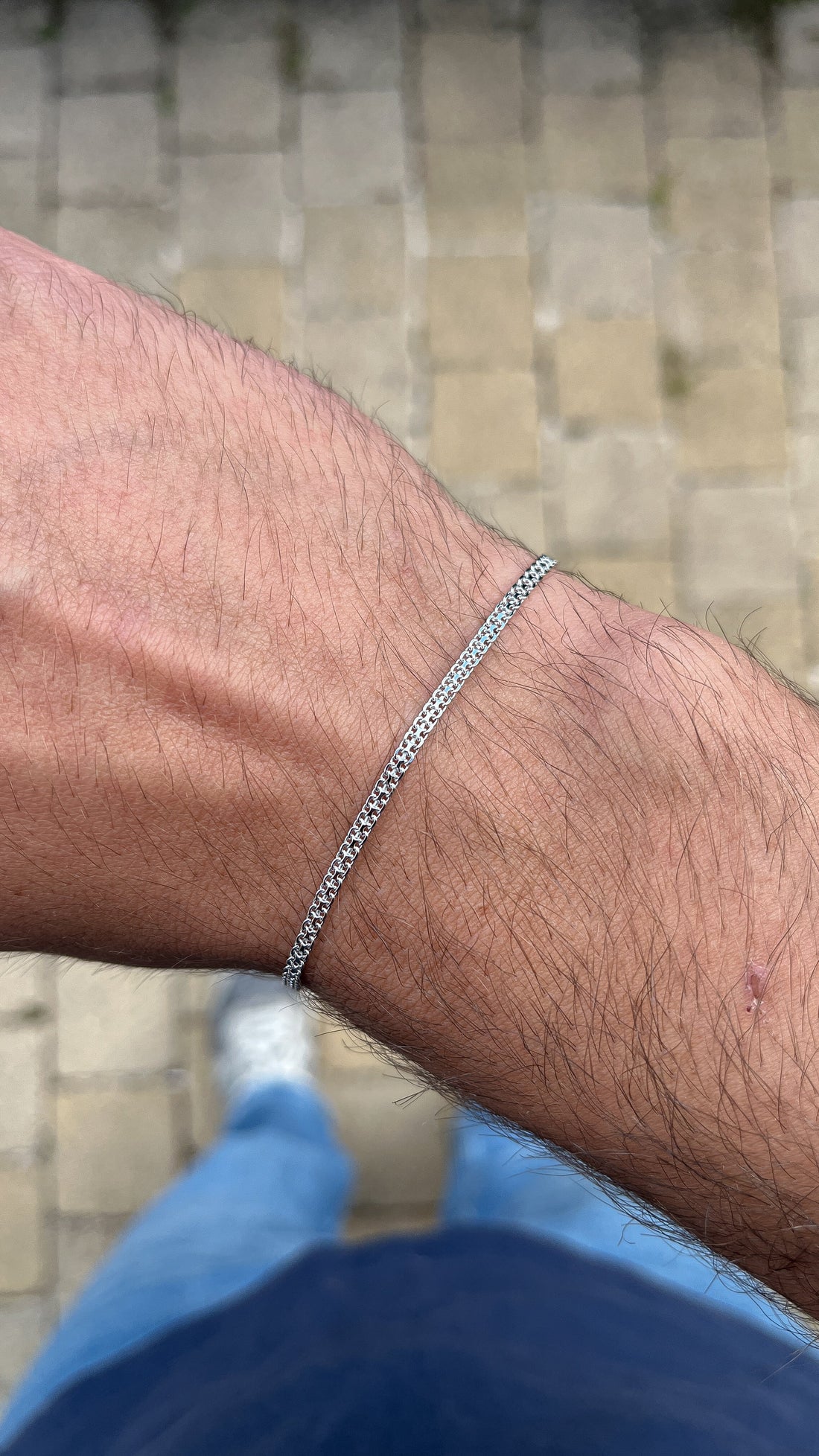 Bracelet chaîne maille Tank en argent porté au poignet d'un homme