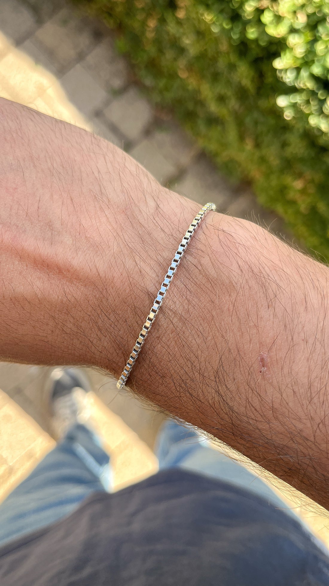 Bracelet chaîne en argent rhodié maille vénitienne porté au poignet d'un homme
