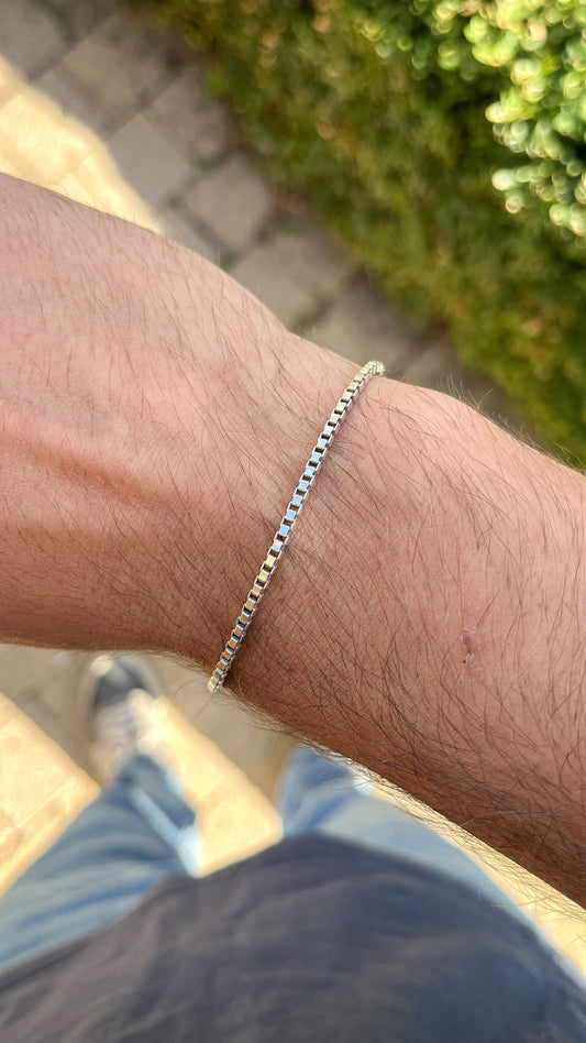 Bracelet chaîne en argent rhodié maille vénitienne porté au poignet d'un homme