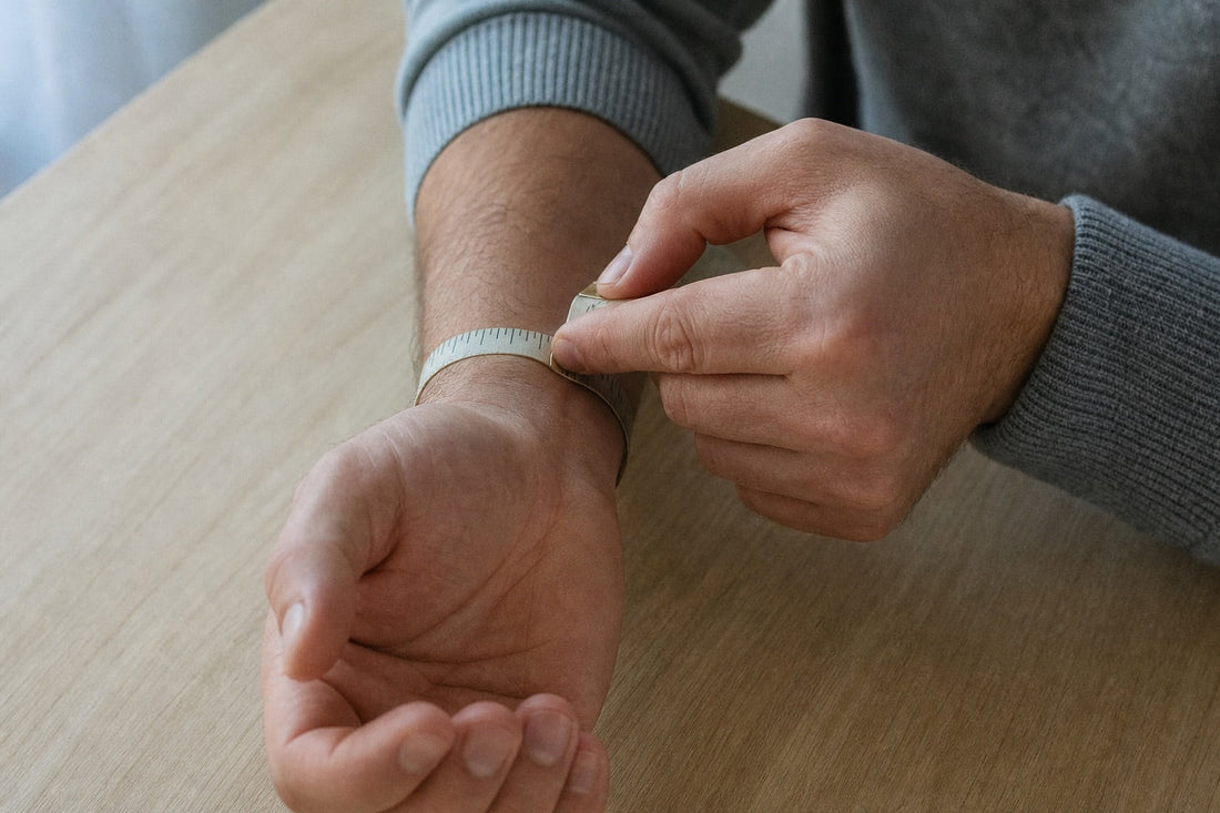 Homme qui mesure son tour de poignet avec un mètre ruban souple posé au niveau de l'os du poignet