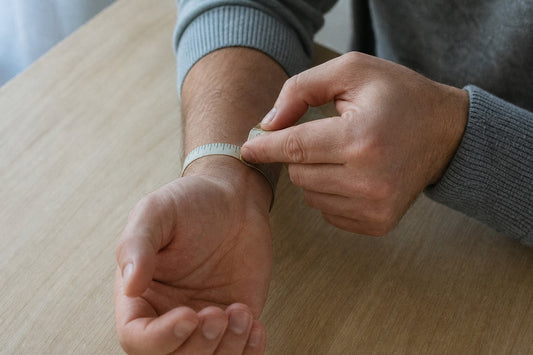 Homme qui mesure son tour de poignet avec un mètre ruban souple posé au niveau de l'os du poignet